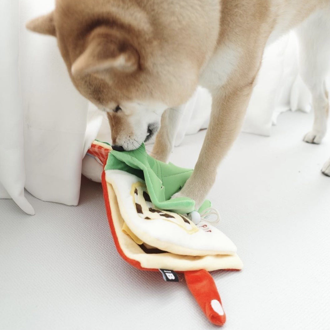 Dog exploring the Pet Book Puzzle Toy, sniffing fabric pages to find hidden treats
